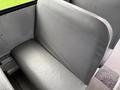 A grey vinyl seat in a 2014 Freightliner B2 showing a smooth surface and curved backrest with no visible wear or signage