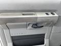 Interior door handle and control panel of a 2009 Ford Econoline with a textured surface and a cup holder