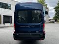 A blue 2017 Ford Transit 350 viewed from the rear showcasing its large windows and distinctive rear design