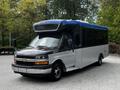 2019 Chevrolet Express with a blue and white exterior featuring a large front windshield and side windows designed for passenger transportation