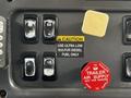 Control panel of a 2010 Freightliner M2 106 with buttons for fuel type and air supply features and a caution label for fuel instructions