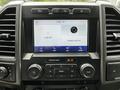 The image features the interior dashboard of a 2020 Ford F-350 SD displaying a touchscreen with audio settings and options to connect a phone