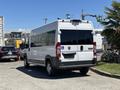 A white 2016 RAM Promaster van is parked in the foreground with blacked-out rear windows and a license plate visible on the back