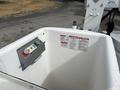A control panel with buttons and warning labels in a bucket attached to a 2017 Ford Econoline vehicle