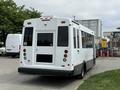 A white 2020 Chevrolet Express bus with large windows and a rear wheelchair access door