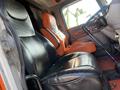 The image shows the interior of a 2009 Peterbilt Highway truck featuring black and orange leather seats and a steering wheel