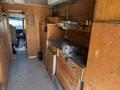 Interior of a 2009 Morgan Olson Workhorse W62 featuring wooden cabinets and a metal workbench with tools on it