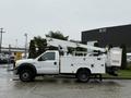 A 2006 Ford F-450 service truck with a white body and a raised aerial lift on the back