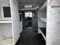 Interior of a 2009 Ford Econoline van showing white storage units and shelving with a driver's seat visible at the front
