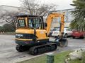 A 2022 Hyundai R55-9A compact excavator with a yellow and black exterior featuring a bucket attached to the arm and tracked undercarriage