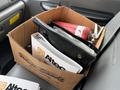 A cardboard box containing a black folder and a red fire extinguisher on the passenger seat of a 2006 Ford F-450