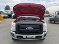 A red 2011 Ford F-250 Super Duty with its hood raised showcasing the engine compartment and front grill