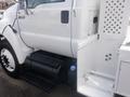 2011 Ford F-750 truck with a white exterior featuring a fuel tank and a side compartment with a checkered design