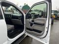 Interior view of a 2016 Ford F-150 with the driver's side door open showcasing the dashboard seats and controls