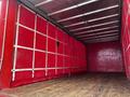 A red 2008 Ford F-750 truck with an empty cargo area featuring wooden flooring and red padded walls