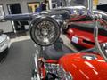 A close-up of a chrome headlight on a 2024 Harley Davidson Fat Boy motorcycle showcasing its detailed design and polished surface