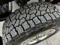 Close-up of a large tire with a rugged tread pattern mounted on a wheel of a 2016 Ford F-150
