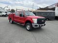 A red 2011 Ford F-250 SD with a truck bed and double cab design is prominently displayed in the foreground