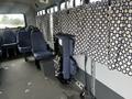 Interior view of a 2012 Chevrolet Express showing upholstered seating and patterned curtains covering the windows