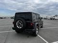 A black 2019 Jeep Wrangler parked with a spare tire mounted on the rear and distinctive round taillights