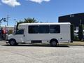 A white 2020 Chevrolet Express shuttle bus is parked with large tinted windows and a high roof design