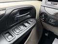 Interior view of a 2017 Dodge Grand Caravan showing the car's door panel with window controls and seat adjustment knobs