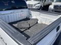 A 2012 Ford F-150 truck bed with black rubber mats laid out and visible dirt and wear on the surface
