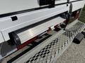 A close-up view of the rear step bumper of a 2023 Ford E-450 showing the step and mounting area