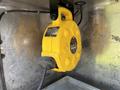 A yellow retractable extension cord reel mounted inside a vehicle structure