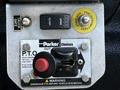 Control panel of a 2017 International WorkStar 7600 featuring switch labels for truck gate and PTO operation with a red lever and cautionary warning label