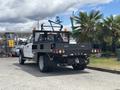 A 2017 Ford F-550 with a flatbed and an open rear, equipped with tool compartments and warning lights, is parked in a lot