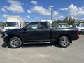 A black 2011 RAM 1500 pickup truck parked with its side view visible showcasing its sleek design and chrome accents