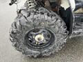 Close-up of a muddy tire from a 2017 Polaris Scrambler showcasing a rugged tread pattern and black rim