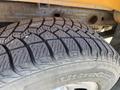 Close-up of a treaded tire from a 2013 Chevrolet Silverado 1500 showcasing detailed patterns on the rubber surface
