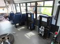 Interior of a 2020 Chevrolet Express showing blue upholstered seats arranged in a row with metal frames and safety features visible