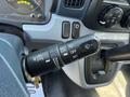 A close-up of the steering column controls of a 2015 Mitsubishi Fuso FE showing the windshield wiper control lever and dashboard switches