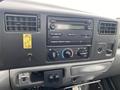 The dashboard of a 2003 Ford F-450 SD featuring the radio control panel climate controls and multiple buttons and knobs