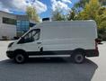 A white 2015 Ford Transit van with a black trim parked on a surface, featuring sliding side doors and a high roof design