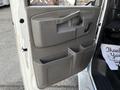 The interior door panel of a 2019 Chevrolet Express featuring a gray plastic finish armrest and multiple storage compartments