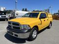 A yellow 2015 RAM 1500 pickup truck with a chrome grille and black accents parked at an outdoor location