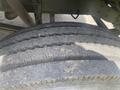 A close-up view of a worn tire with visible cracks and rough texture on the tread surface