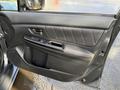 The image shows the interior door panel of a 2021 Subaru WRX featuring a sleek design with red stitching and various controls for windows and locks