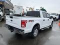A white 2016 Ford F-150 pickup truck with a chrome rear bumper and FX4 off-road emblem parked in a lot