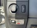 Dashboard controls of a 2012 Ford F-450 SD including a headlight switch and a button for activating a system