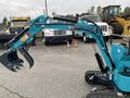 A 2024 AGT Mini Excavator with a blue arm and claw attachment is positioned in the foreground ready for operation