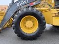 A 2011 John Deere 310SJ 4x4 Wheel Loader with an extended hoe and a 4 in 1 bucket featuring a large tire showcasing tread design and a yellow rim