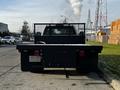 A 2017 Chevrolet Silverado 3500HD truck with a flatbed configuration viewed from the rear showcasing its taillights and hitch receiver