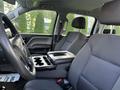 Interior view of a 2017 GMC Sierra 1500 showcasing the driver's seat and center console with cup holders and storage compartment