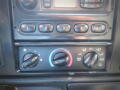 Control panel of a 2005 Ford F-750 featuring knobs for climate control and audio settings