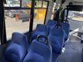 Interior view of a 2017 Chevrolet Express with several blue padded seats arranged in rows